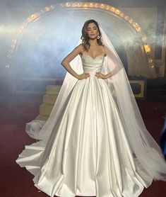 a woman in a white wedding dress posing for the camera