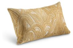 a gold and white pillow with wavy lines on the front, sitting on a white surface