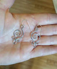 "Sterling silver 18 gauge wire is swirled and looped into this Celtic influenced spiral earrings design. We hammered the earrings for extra strength and character. These very light weight earrings are great every day! The entire earring measures about 1 1/8- 1 3/8\" (2.9- 3.4 cm) from the top loop to the bottom of the earrings. The earwire adds about 1/2\" maiking them a total length of about 1 5/8-1 7/8\" (4.1-4.8cm) from the top of the earwire to the bottom of the earring. It is about 1/2\" (1 Silver Spiral Wrap Earrings, Pierced, Handmade Silver Swirl Earrings, Sterling Silver Swirl Jewelry With Matching Earrings, Nickel Free Silver Swirl Earrings, Sterling Silver Swirl Earrings For Gift, Swirl Shaped Sterling Silver Earrings For Gifts, Silver Swirl Pierced Earrings, Spiral Silver-plated Wire Earrings, Sterling Silver Swirl Earrings