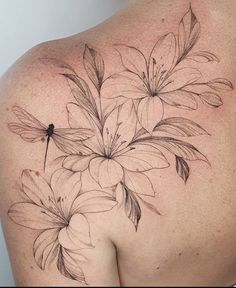 the back of a woman's shoulder with flowers and dragonflys on it