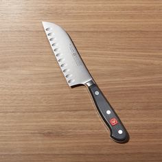 a large knife sitting on top of a wooden table