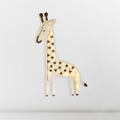 a light up giraffe standing next to a white wall