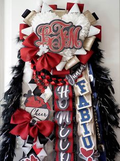 a wreath made out of candy bar wrappers and ribbons with monogrammed letters