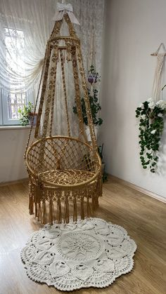 a hammock hanging from the ceiling in a room with wood floors and white curtains