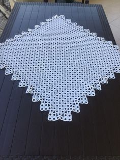 a black table with white doily sitting on top of it