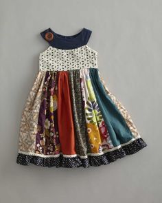 a dress made out of different fabrics and fabric material, with buttons on the collar