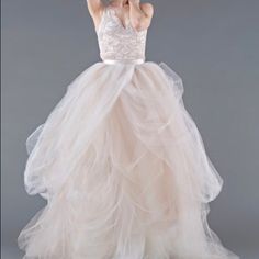 a woman in a white dress is posing for the camera with her hands behind her head