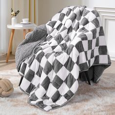 a black and white checkered blanket sitting on top of a chair next to a teddy bear