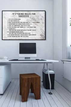 a white desk with a computer on it and a poster above it that says f - word rules for success