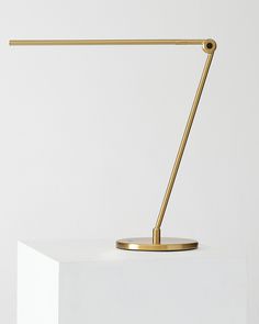 a desk lamp sitting on top of a white block in front of a white wall