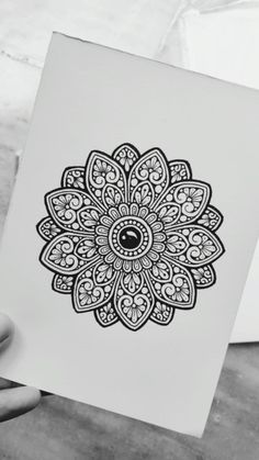 a person holding up a card with an intricate design on it