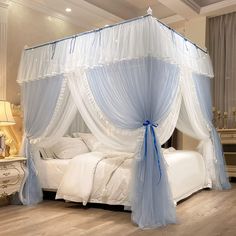 a bed with white and blue drapes on it