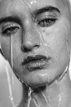 black and white photograph of a woman's face with water dripping from her mouth