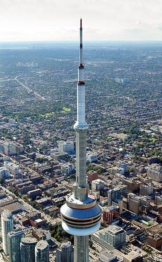 an aerial view of a tall building in the middle of a city with skyscrapers