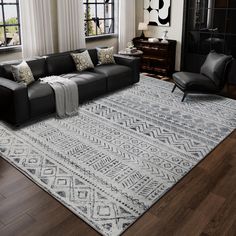 a living room with a couch, chair and large rug in front of two windows