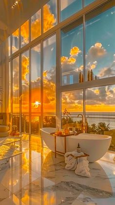 a bathroom with large windows and a bathtub next to the window overlooking the ocean