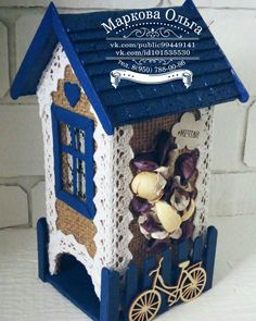 a blue and white birdhouse with flowers in it