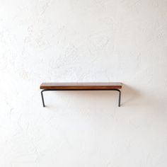 a wooden shelf mounted to the side of a wall