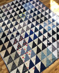 a blue and white quilt sitting on top of a wooden floor