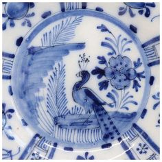 a blue and white plate with an image of a bird on it's side