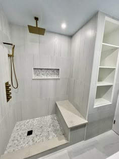 a walk in shower sitting next to a white shelf