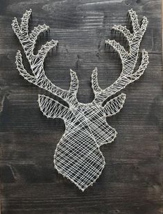 a string art deer head mounted on a wooden wall