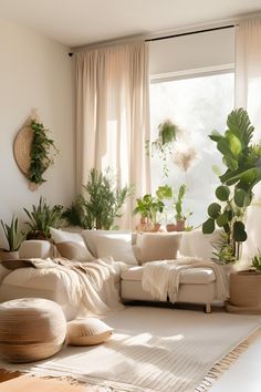 a living room filled with lots of plants next to a large white couch in front of a window