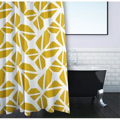 a bath tub sitting next to a white and yellow shower curtain in a bathroom under a window