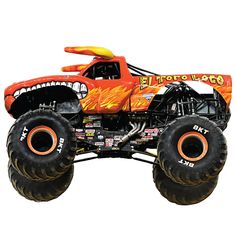 an orange monster truck with big tires on it's back and flames painted on the front