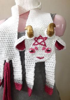 the cow is wearing a knitted scarf with horns on it's head and ears