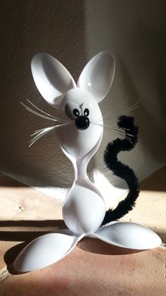 a white cat statue sitting on top of a floor