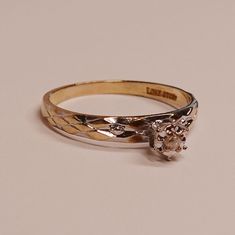 a close up of a ring with a diamond on the top and an engraving design on the bottom