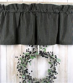 a black and white striped curtain with a wreath hanging on it