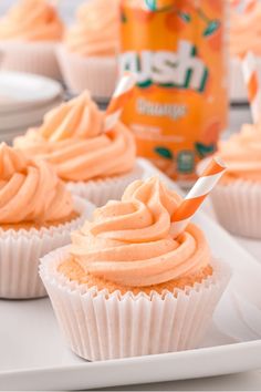 cupcakes with orange frosting and a straw sticking out of the icing