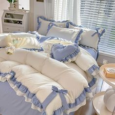 a bed with blue and white ruffled bedspread, pillows and pillow cases