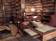 an old library filled with lots of books and desks covered in papers on top of wooden shelves