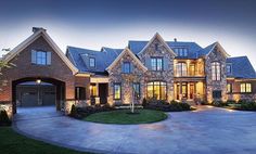 a large house with lots of windows and lights on it's front lawn area