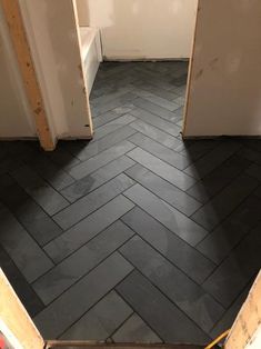 an open door leading into a room with black tile