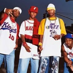 four young men standing next to each other in front of a street light and telephone pole