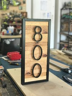 a wooden sign with the number eight on it in front of some workbench tools