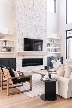 a living room filled with furniture and a flat screen tv mounted on the wall above a fireplace