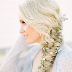 a woman with long blonde hair wearing a braid and flowers in it's hair