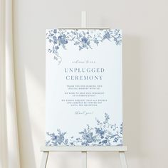 an unplugged ceremony sign is displayed in front of a white background with blue flowers