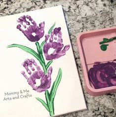 a card with purple flowers in it next to a pink box filled with watercolors