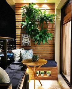 a balcony with plants on the wall and a table in the corner next to it