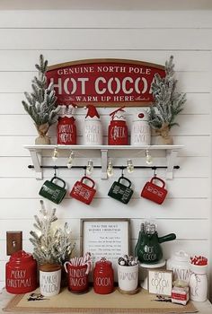 a shelf filled with lots of christmas items on top of a wooden table next to a white wall