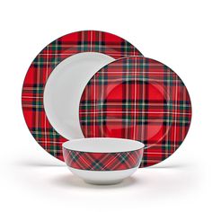 a red and green plaid dinnerware set with a white plate, bowl and fork