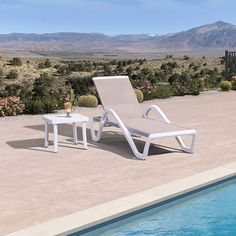 an empty lounge chair next to a swimming pool