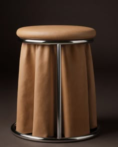 a round stool with a tan cover on it