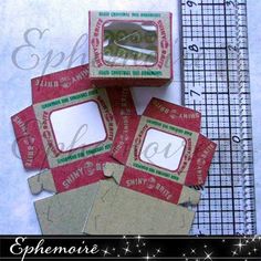 four pieces of red and white paper sitting on top of a table next to a ruler